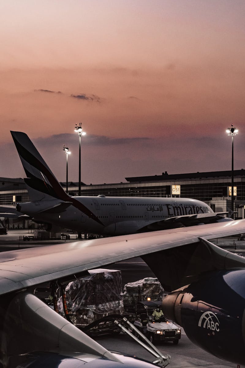 Beautiful view of airplanes parked at an airport terminal during sunset, showcasing aviation technology.